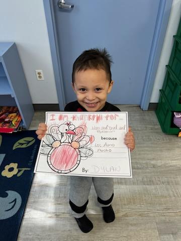 Preschooler holding turkey drawing
